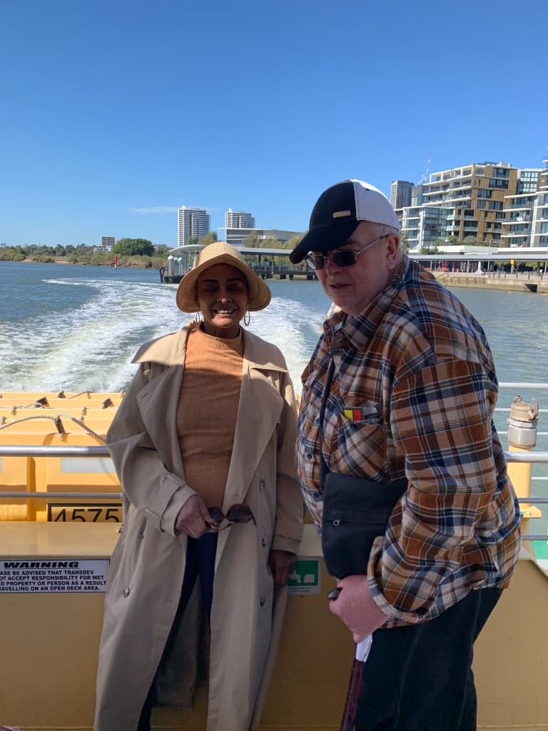 Two people enjoying a ferry ride across the water on a bright day