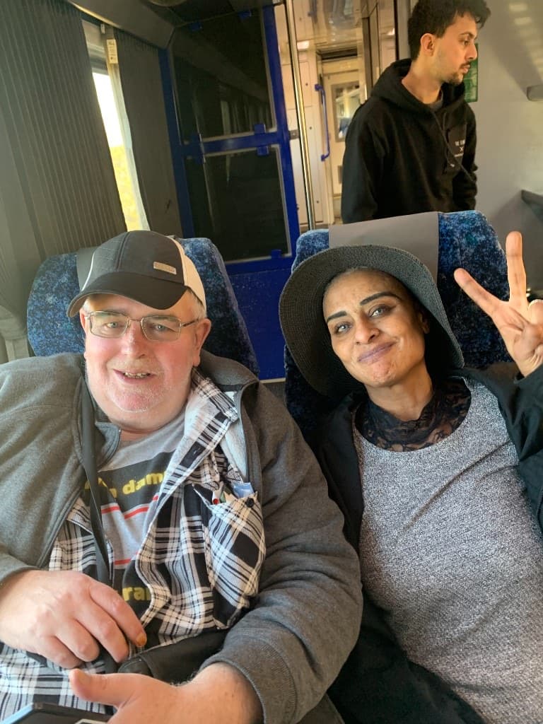 Two people sharing a relaxed, happy moment together on a train journey